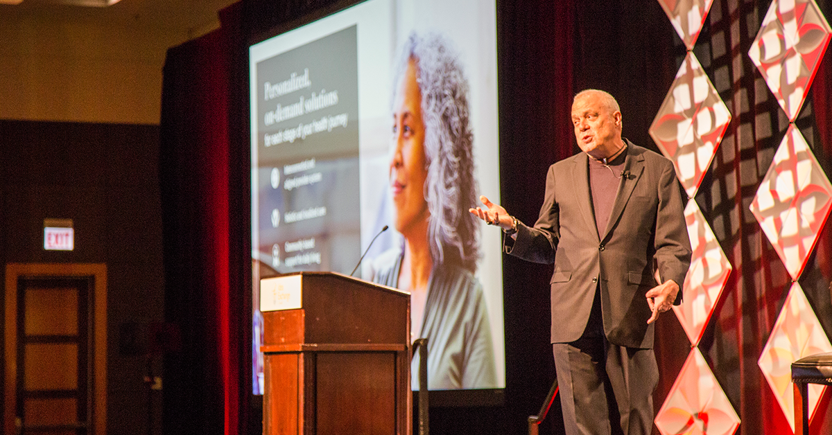 Mark Bertolini of Aetna speaking at bswift's Idea Exchange conference in 2018