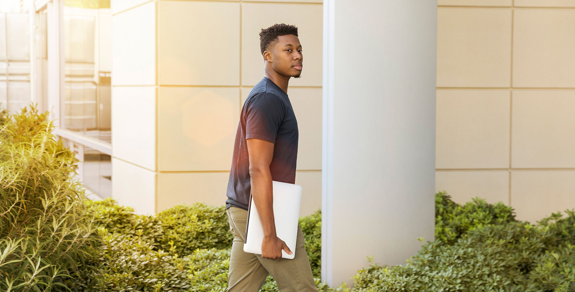Student walking to class with laptop