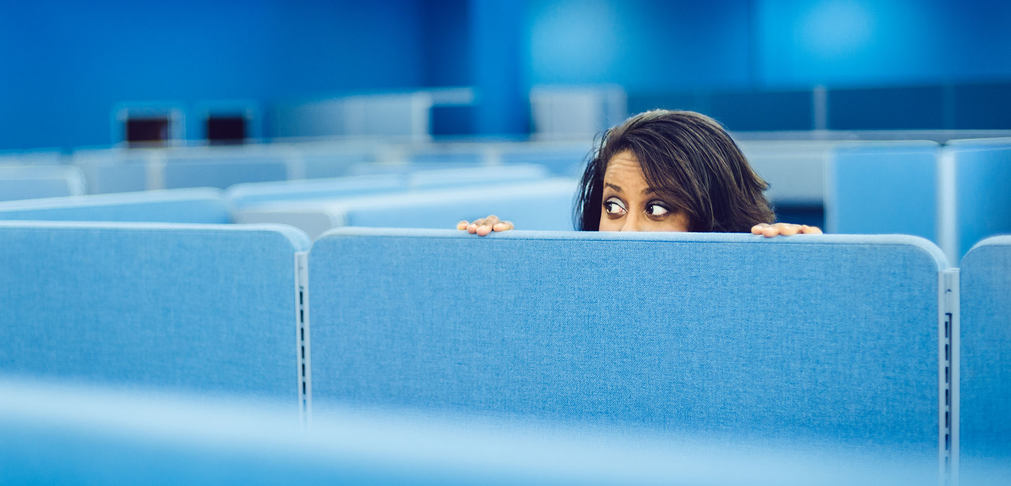 Woman looking over cubicle