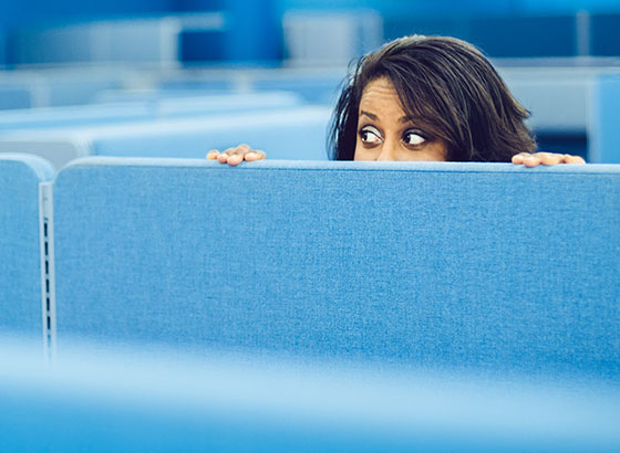 Woman looking over cubicle